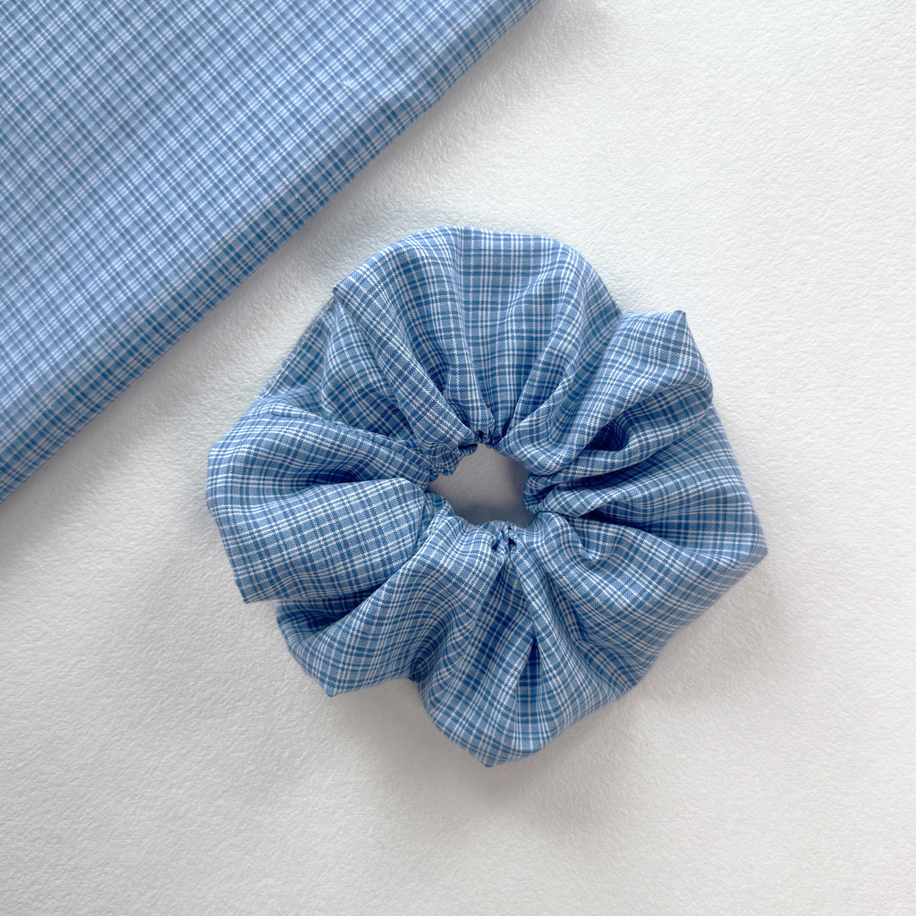 Close-up of blue and white checkered fabric on a linen scrunchie, breathable material for hair health.
