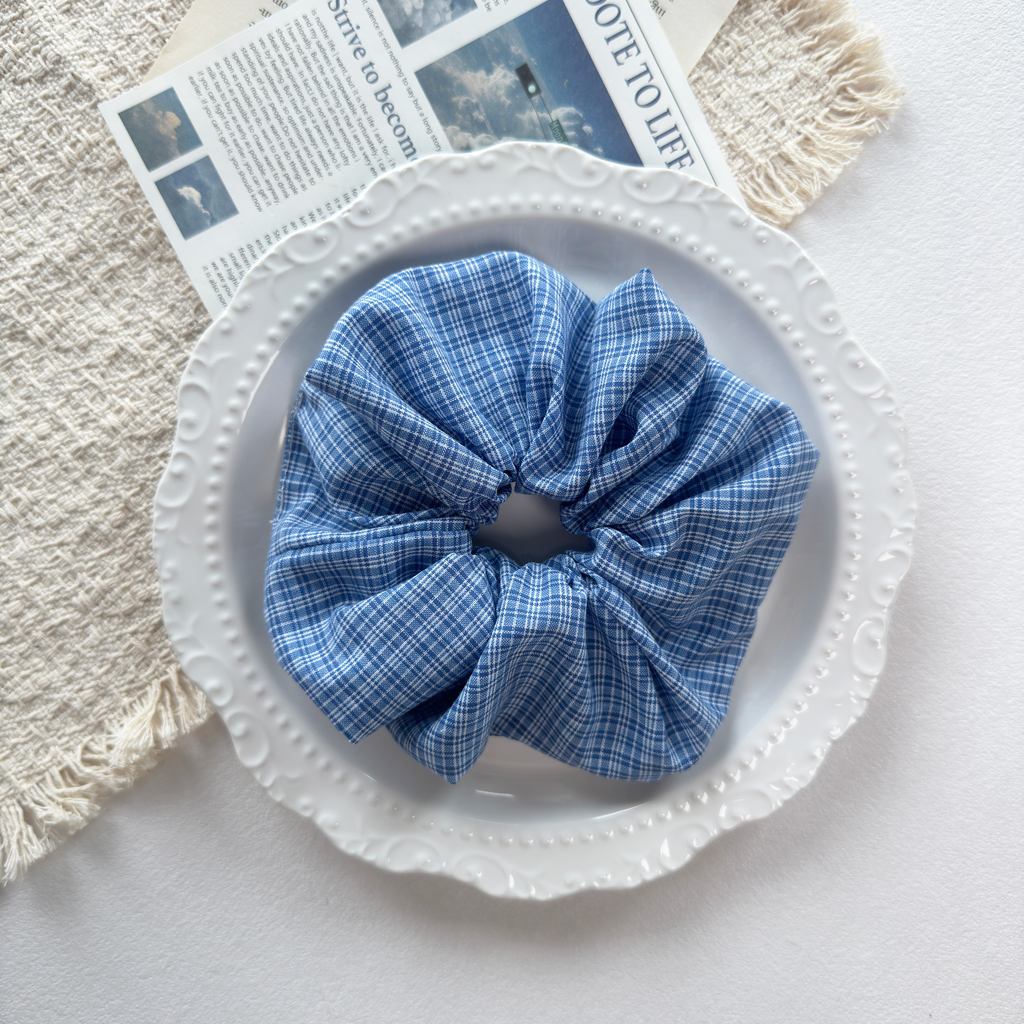 Blue gingham linen scrunchie used as a stylish accessory, classic everyday fashion hair tie.