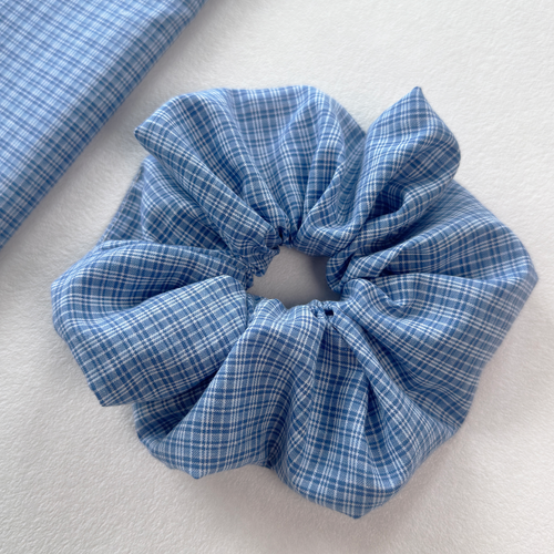 Close detail of a blue gingham linen scrunchie, showcasing high-quality cotton linen blend and texture.