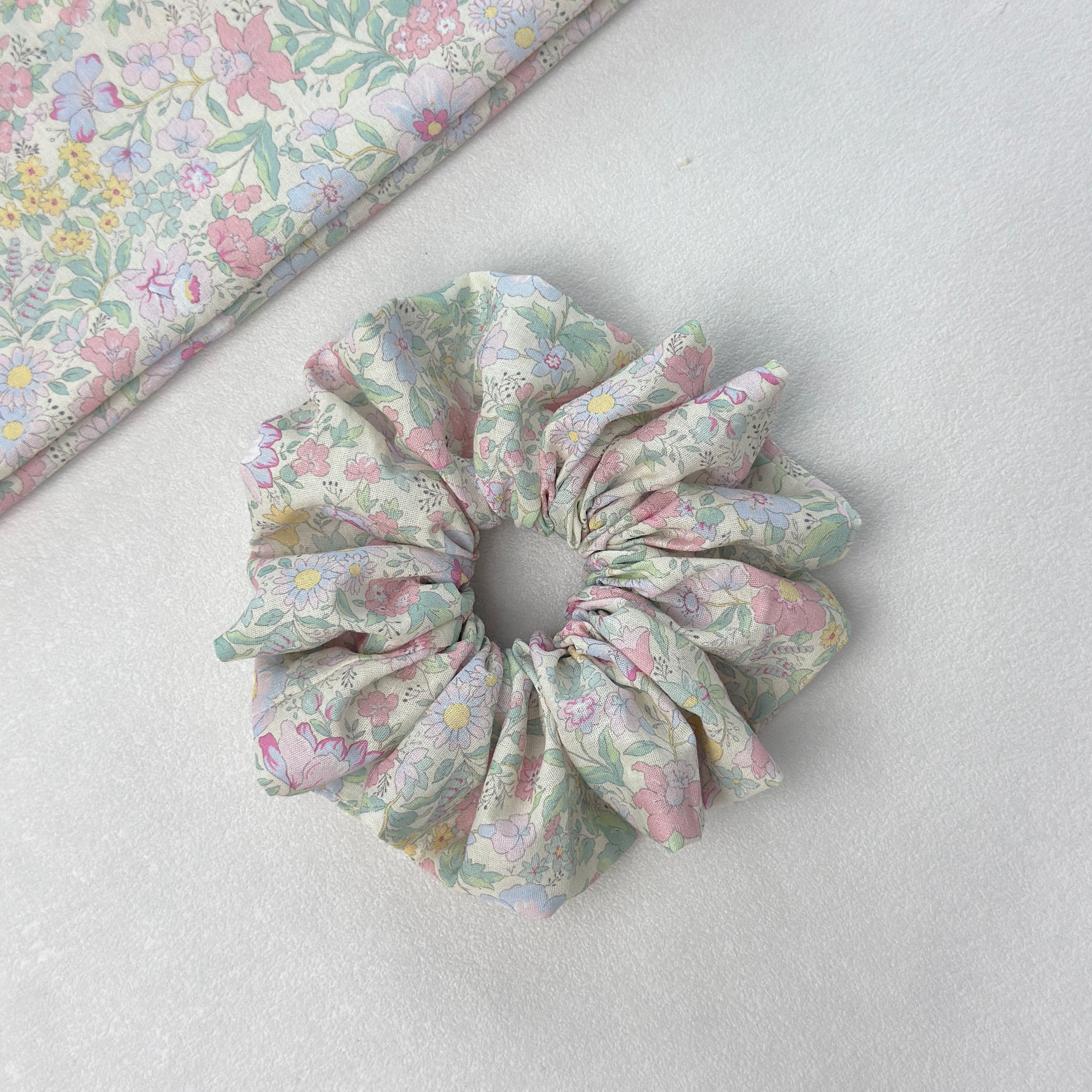 Vibrant floral scrunchie with matching fabric on white background, premium linen blend for mood-boosting style.