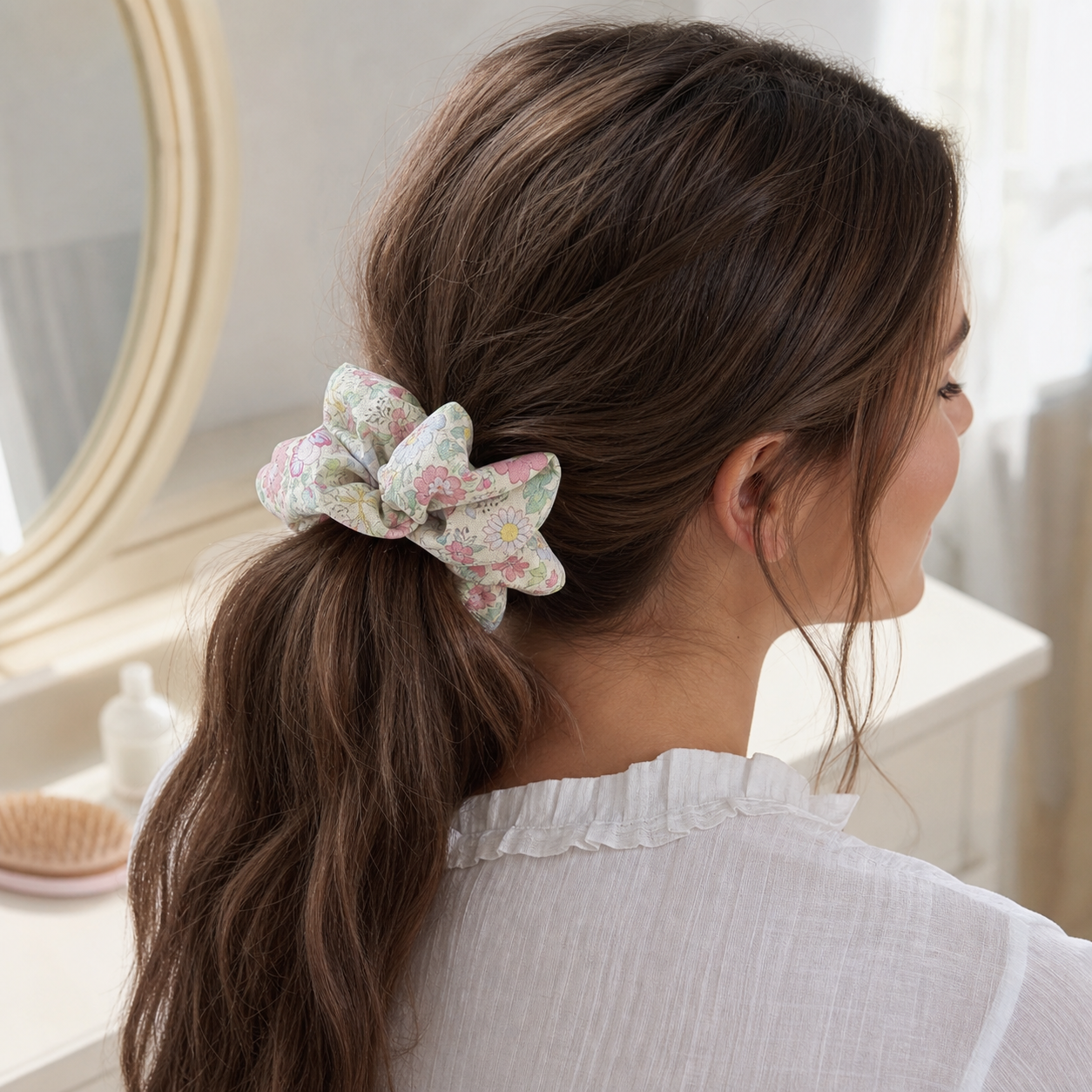 Brown hair model with a low ponytail using a dopamine floral scrunchie, vibrant linen blend for hair care.