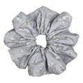 Single dusty blue scrunchie with ditsy white floral print isolated on white background. Voluminous ruffled design with tiny cream blossoms and charcoal-grey stems across a woven cotton base.