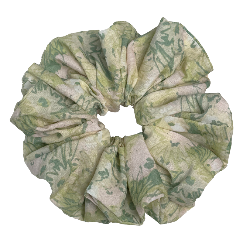 Single cream green floral print scrunchie isolated on white background. Voluminous ruffled design with watercolor sage and olive botanical print and subtle dusty pink accents.
