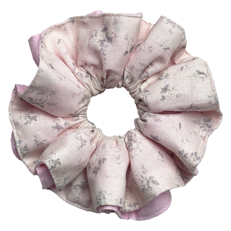 Single dusty blush floral print scrunchie with a solid medium pink underlayer peeking through the ruffles, isolated on white background. Voluminous double-layer design with faded grey-lavender floral print.