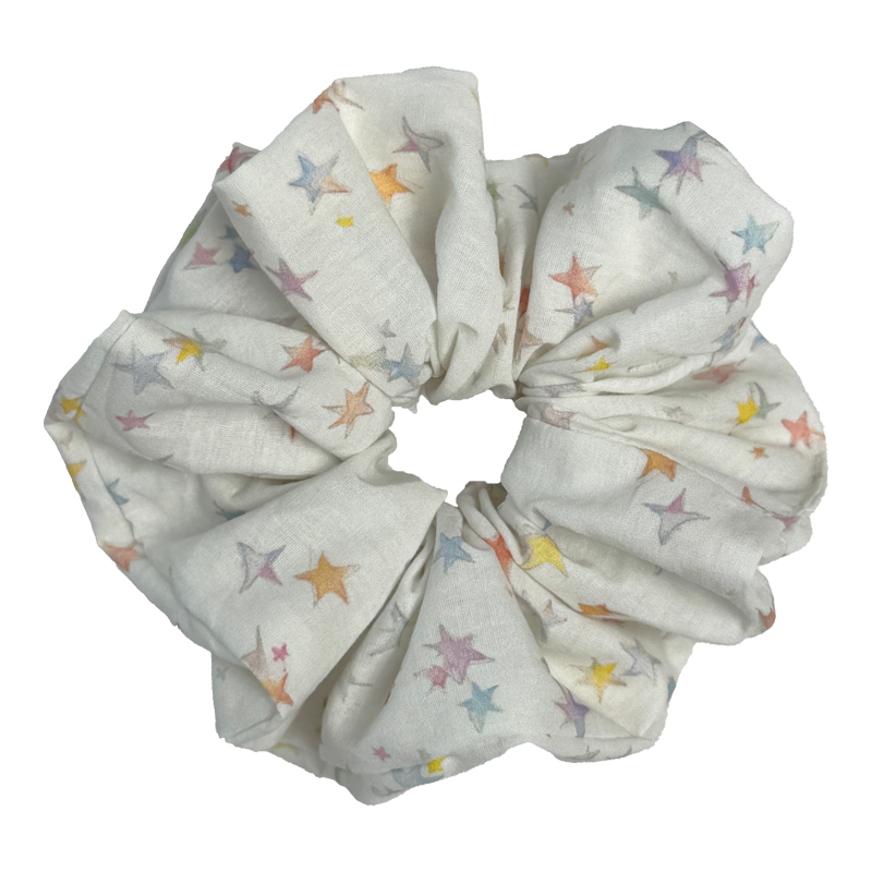 Single white pastel star print scrunchie isolated on white background. Voluminous ruffled design with multicolor sketched stars.