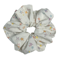 Single white pastel star print scrunchie isolated on white background. Voluminous ruffled design with multicolor sketched stars.