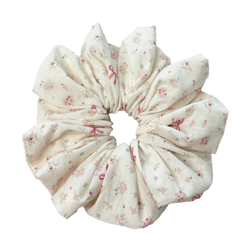 Front view of pink floral bow scrunchie on cream linen blend, no-crease hair protection and vintage style.