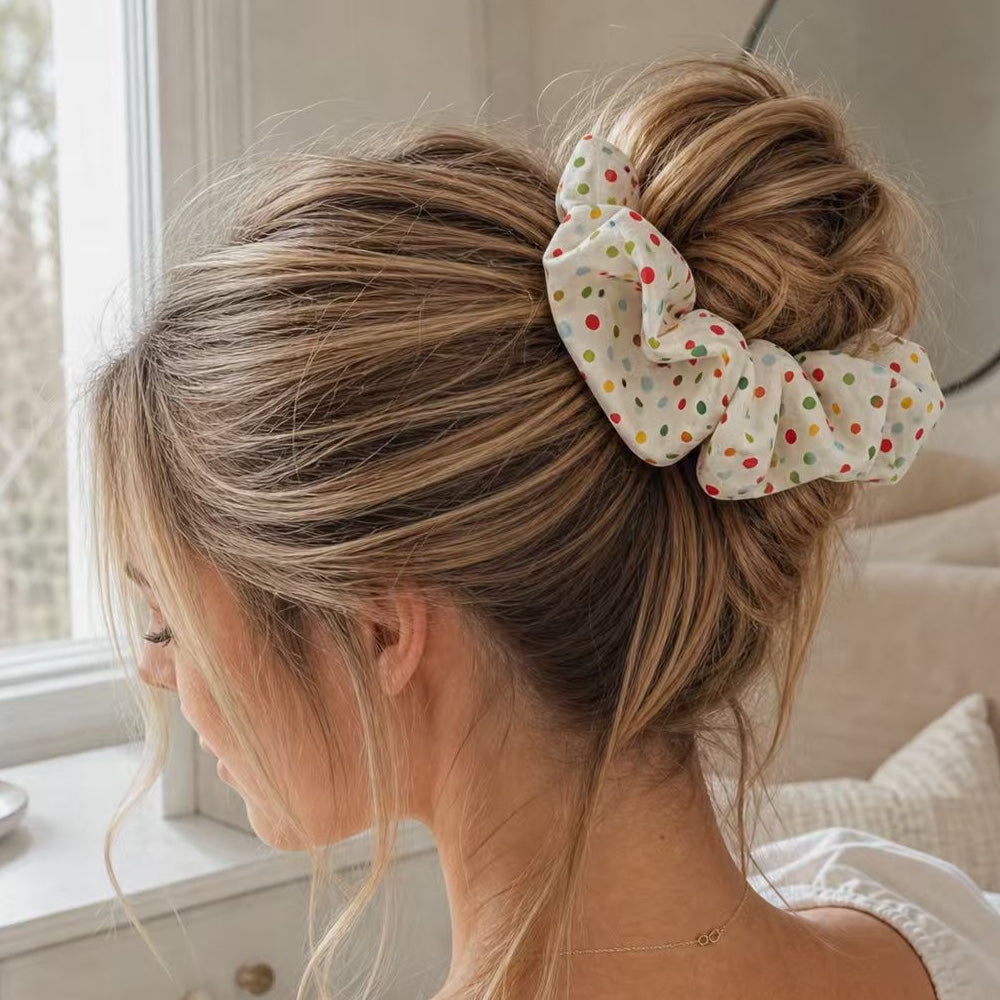 Messy bun hairstyle featuring a breathable cream polka dot linen scrunchie.