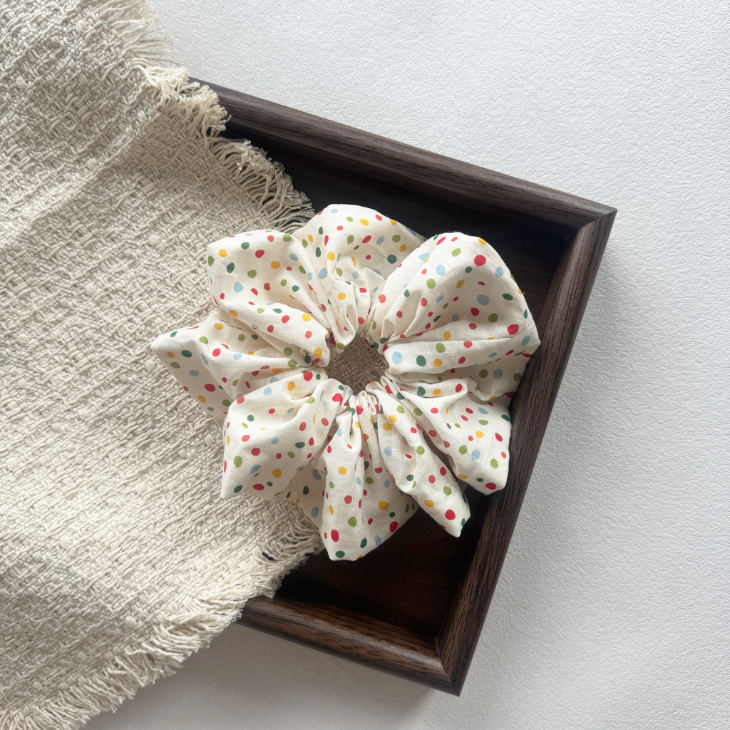Detailed side view of a colorful polka dot linen scrunchie, handmade quality.