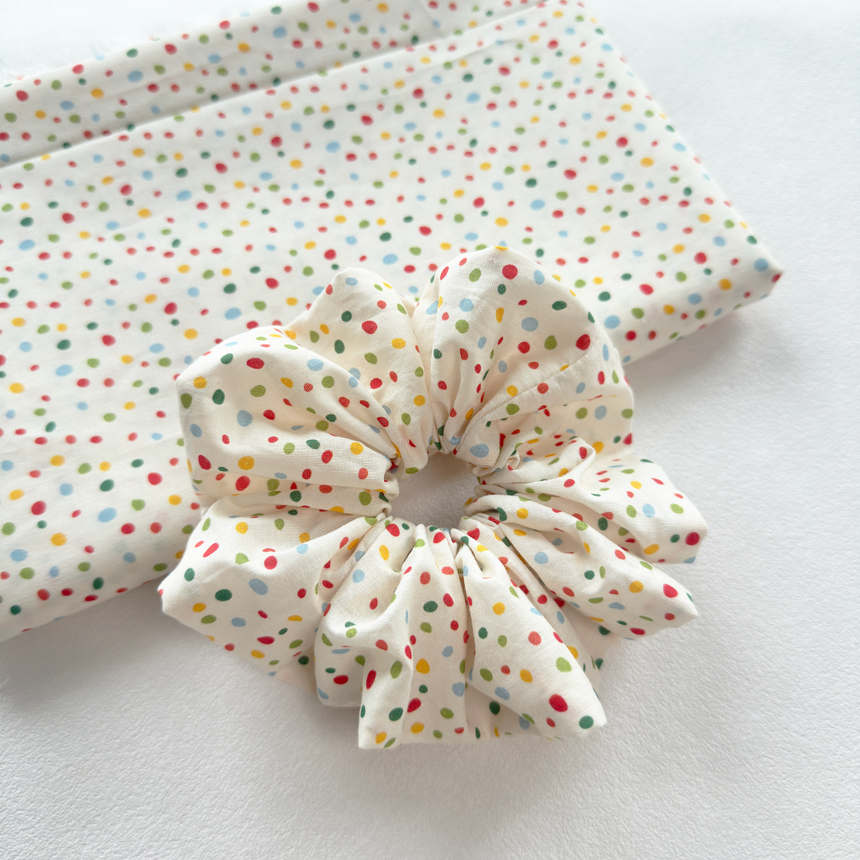 Durable elastic stretch of a polka dot linen scrunchie for all hair types.