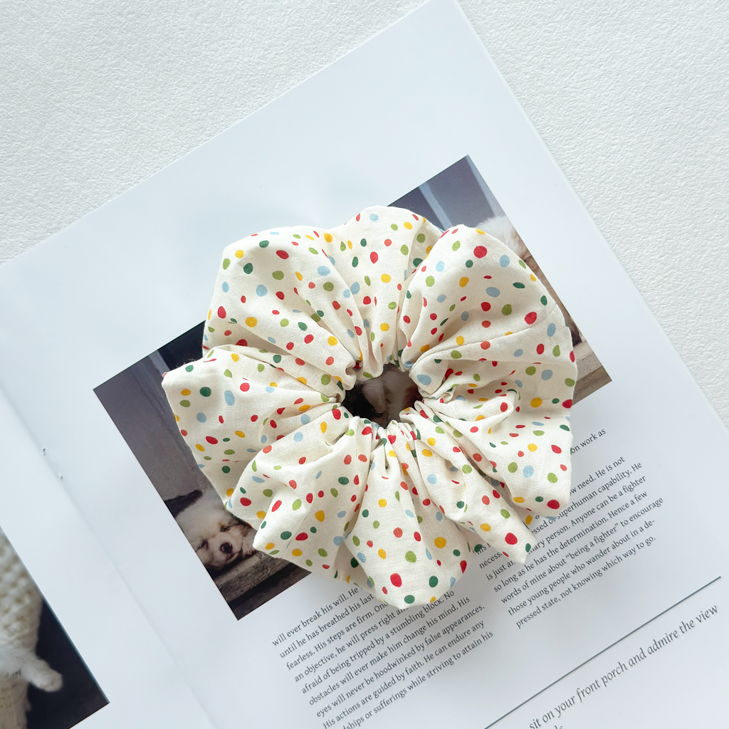 Polka dot scrunchie put on a stylish book in cream.