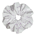 Single white scrunchie with scattered lavender star print isolated on white background. Voluminous ruffled design with lightweight woven cotton texture and soft deep folds.