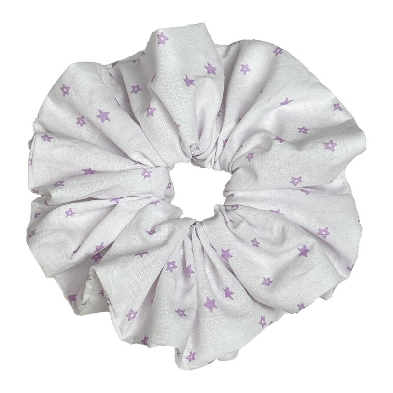 Single white scrunchie with scattered lavender star print isolated on white background. Voluminous ruffled design with lightweight woven cotton texture and soft deep folds.