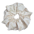Single cream yellow floral print scrunchie isolated on white background. Voluminous ruffled design with pale pink blossoms and olive green leaves on a soft cream base.